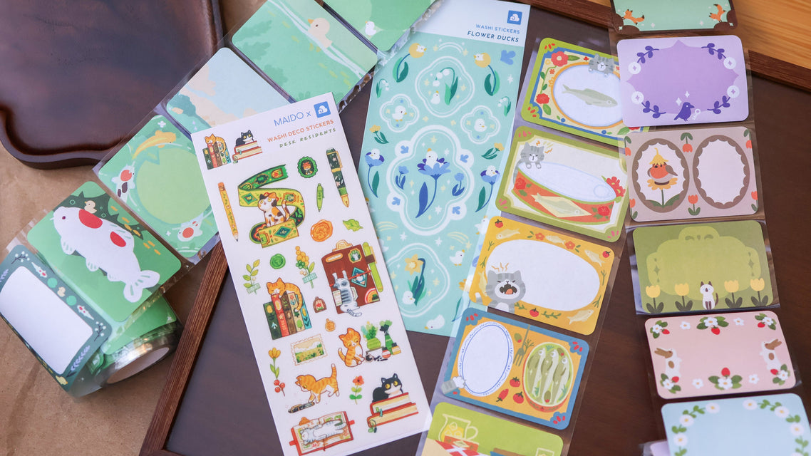 Collection of colorful stationery items including cards and stickers on a wooden surface.