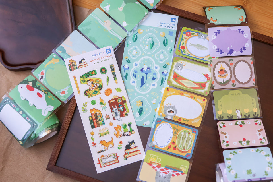 Collection of colorful stationery items including cards and stickers on a wooden surface.