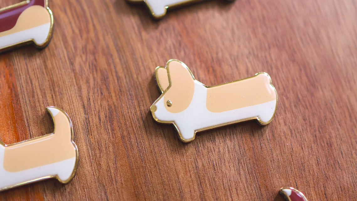 Corgi shaped magnets on a wooden surface